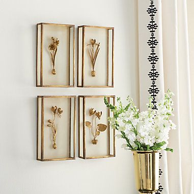 three framed flowers are hanging on the wall next to a vase with white flowers in it