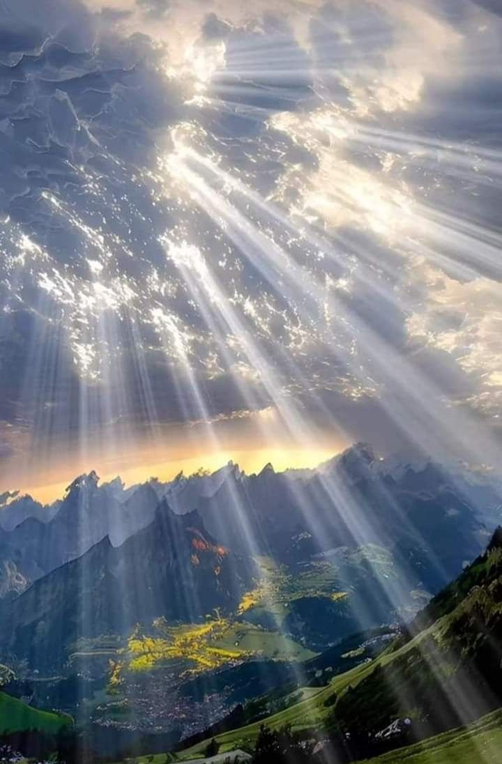 the sun shines brightly through the clouds in the sky over mountains and valleys below