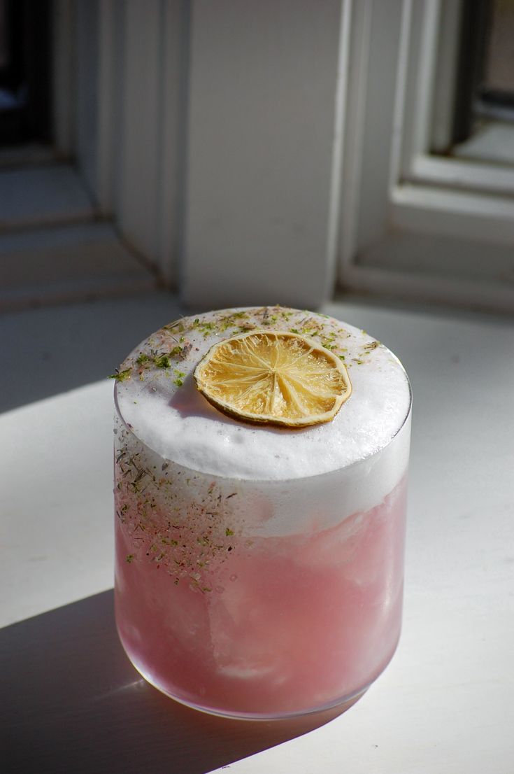 a pink and white cake with a lemon slice on top