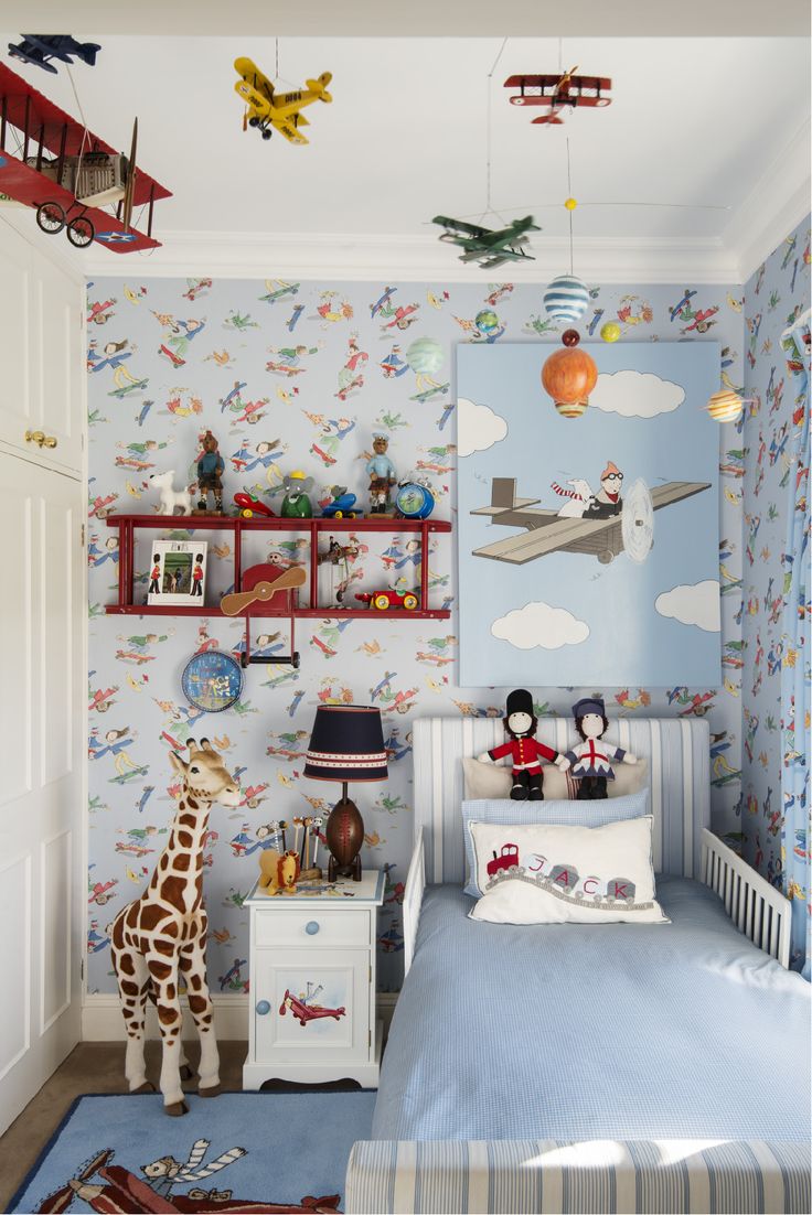 a child's bedroom decorated in blue and white with toys on the wall, including a toy giraffe