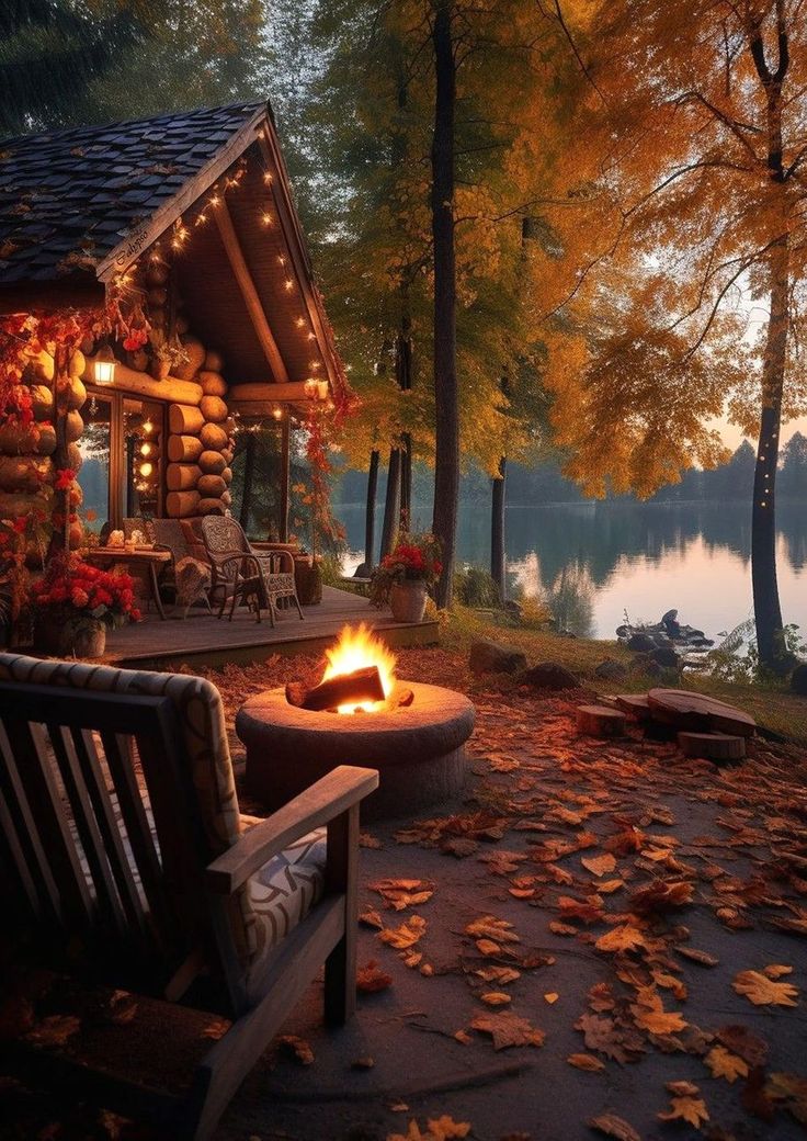 a log cabin with a fire pit in the foreground and autumn leaves on the ground