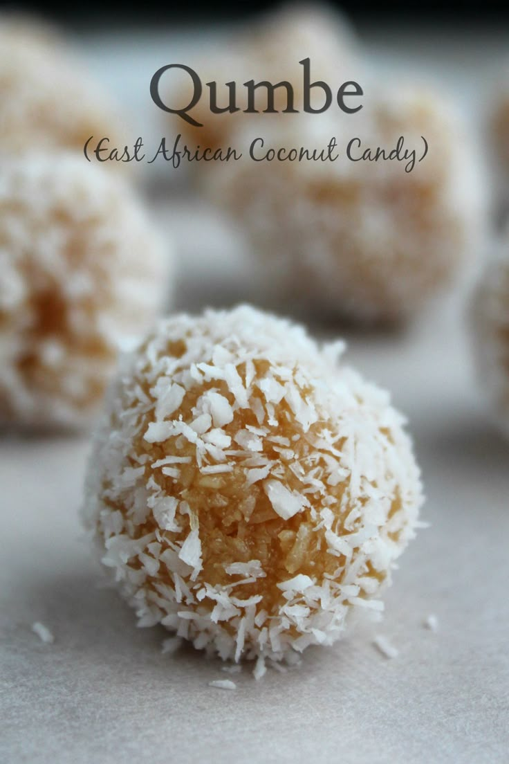 some coconut balls are sitting on a white surface with the words quimbe in front of them