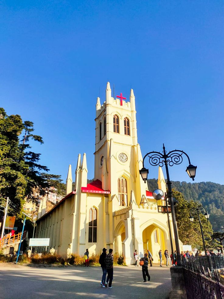 two people are standing in front of a church