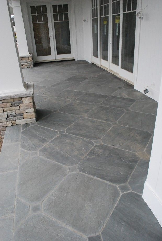 an empty patio with stone steps leading to the front door