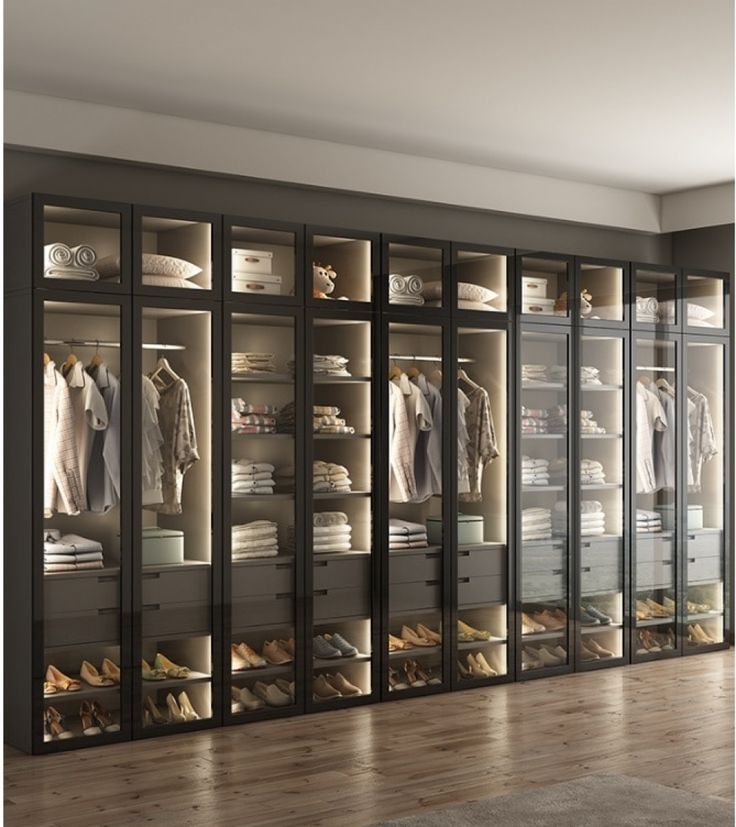 a walk in closet filled with lots of clothes and shoes next to a wooden floor