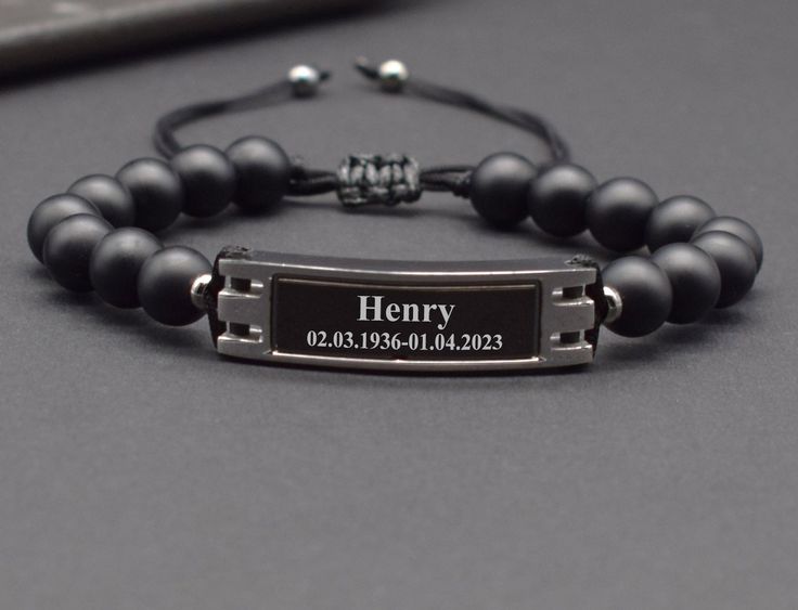 a black beaded bracelet with a name tag on it