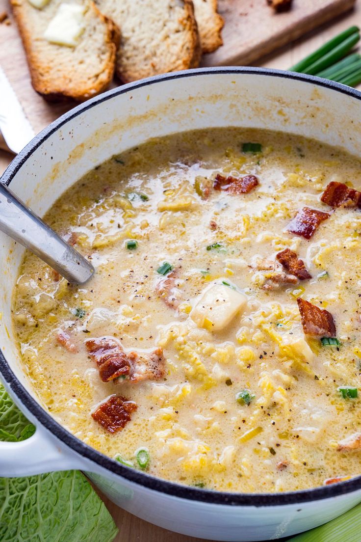 a white bowl filled with soup next to some bread