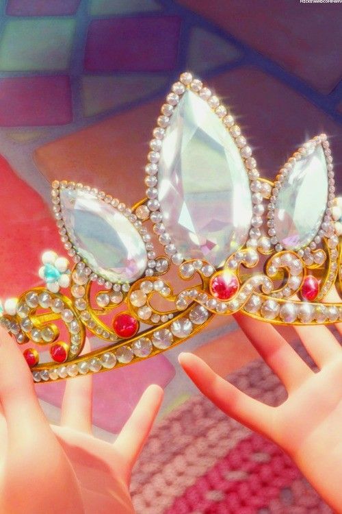 a close up of a person's hand holding a tiara