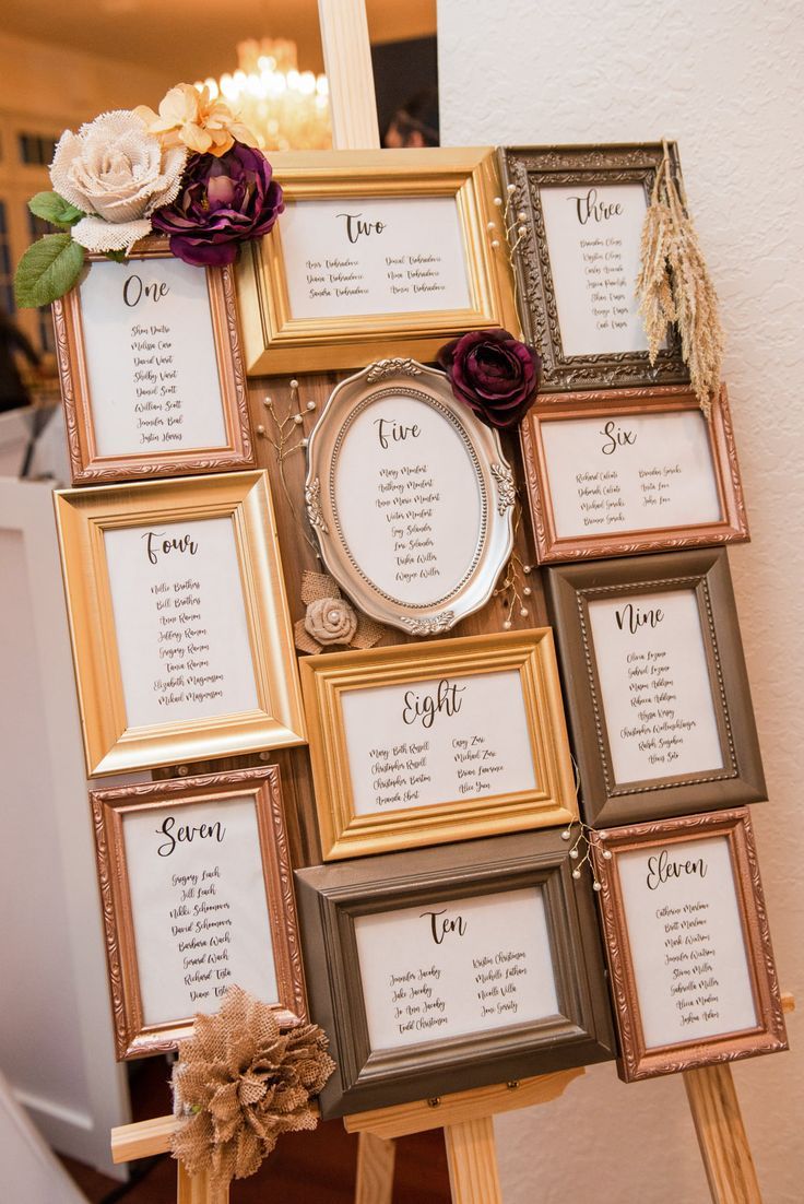 an easel with several frames and flowers on it that have seating cards attached to them