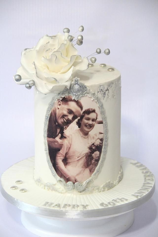 a wedding cake decorated with an old photo and a white rose