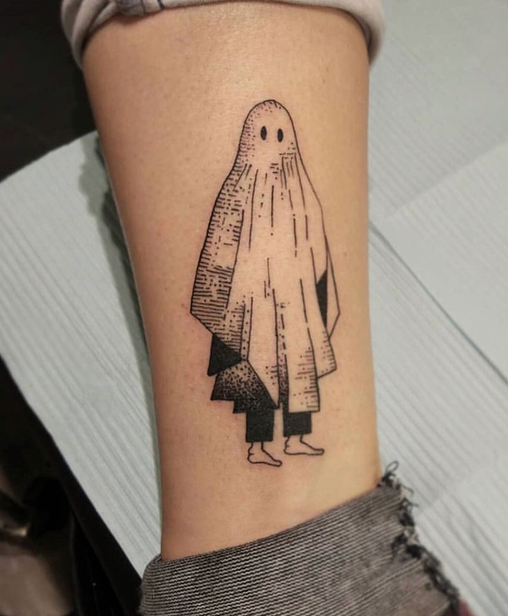 a woman's arm with a tattoo on it that has a drawing of a ghost