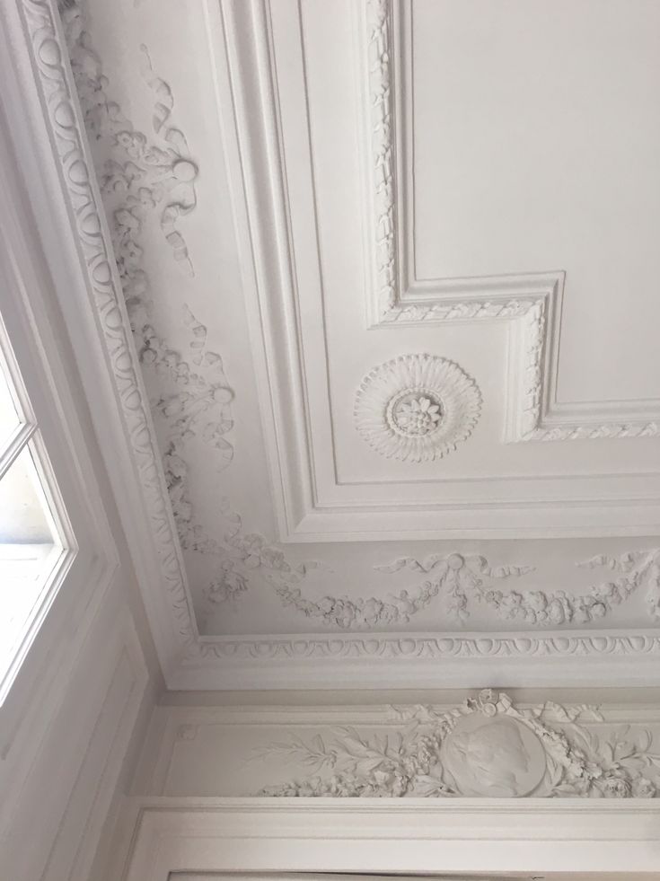 the ceiling is painted white and has ornate designs on it