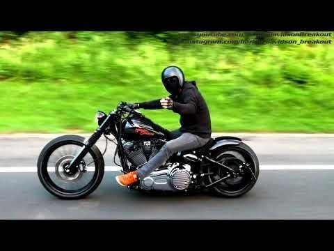 a man riding on the back of a motorcycle down a road with trees in the background