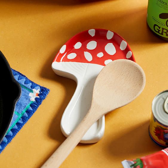 a wooden spoon sitting on top of a table next to cans of soda and a can