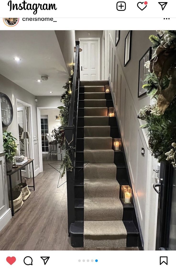 the stairs in this house are decorated with candles and greenery on either side, along with potted plants