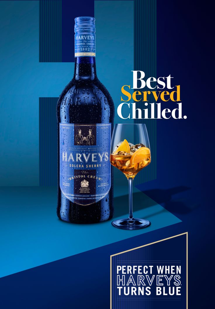 a bottle of harvey's blue wine next to a glass filled with orange peels