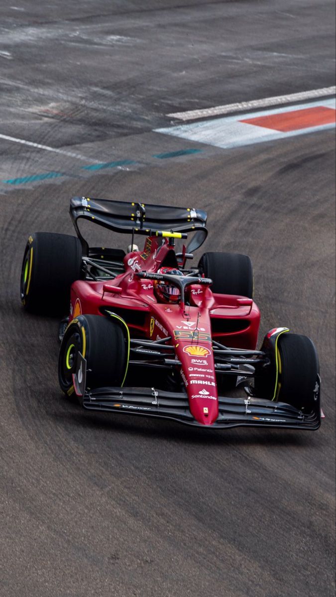 two racing cars driving on a track with one being pushed behind the other by another