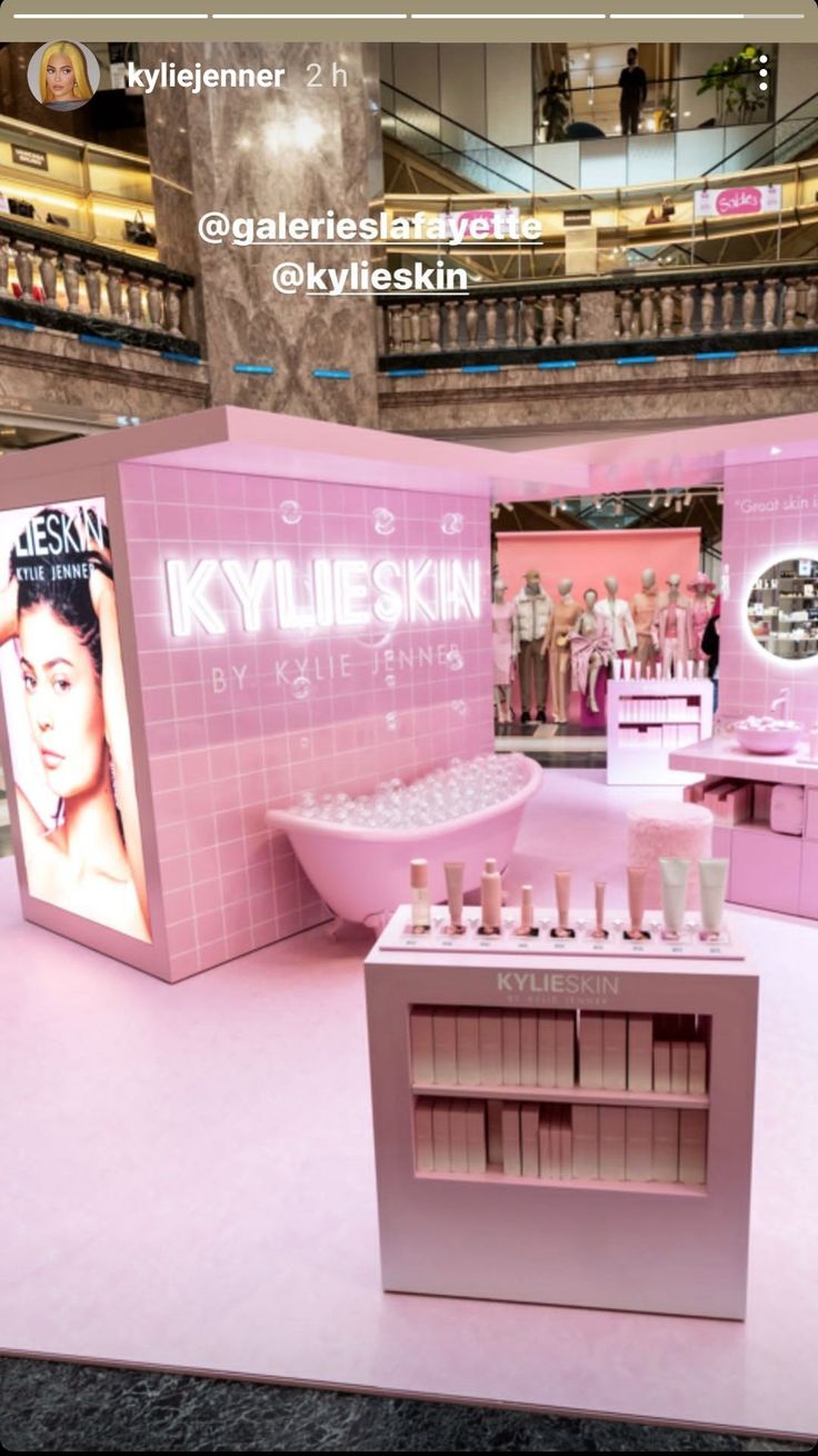 a display in a mall with pink tiles and white bottles on the shelves, along with an advertisement for kylle skin