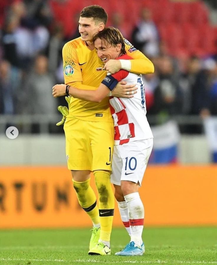 two soccer players hugging each other on the field