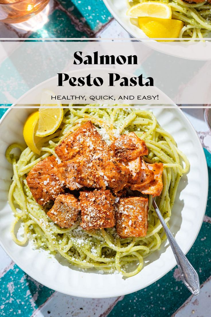 salmon pesto pasta in a white bowl with lemon wedges and parmesan cheese