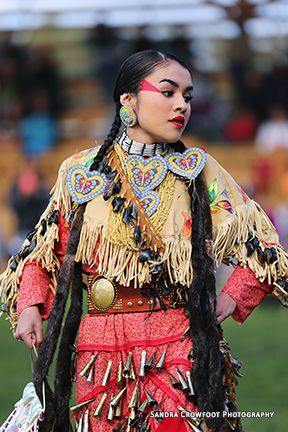 a woman with long hair wearing an elaborate costume and holding a bag in her hand