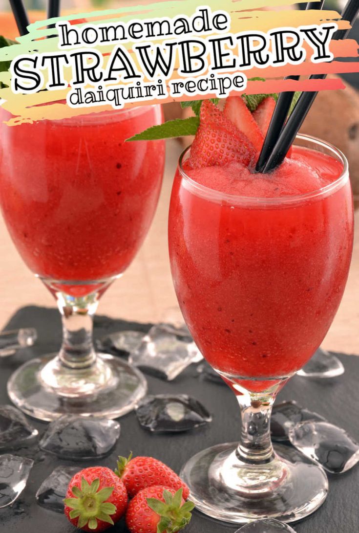 two glasses filled with strawberries sitting next to each other on a black tablecloth