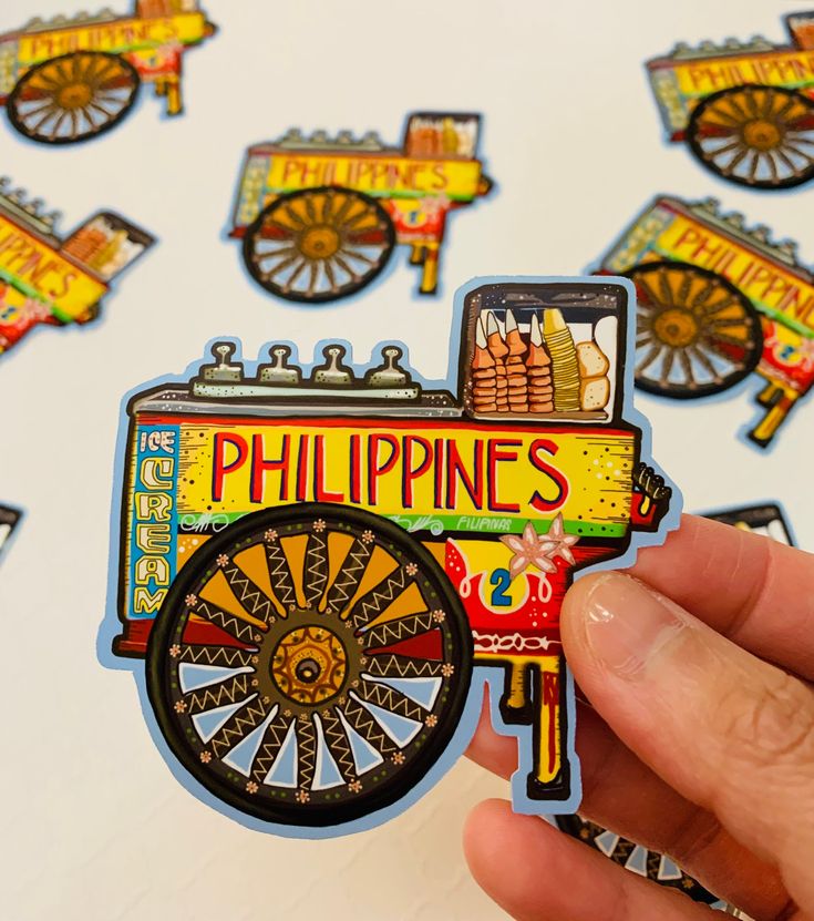 a hand holding up a sticker with an image of a cart on it and the words philippines