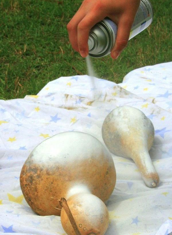 someone is spray painting the top of two snails on a tablecloth with grass in the background