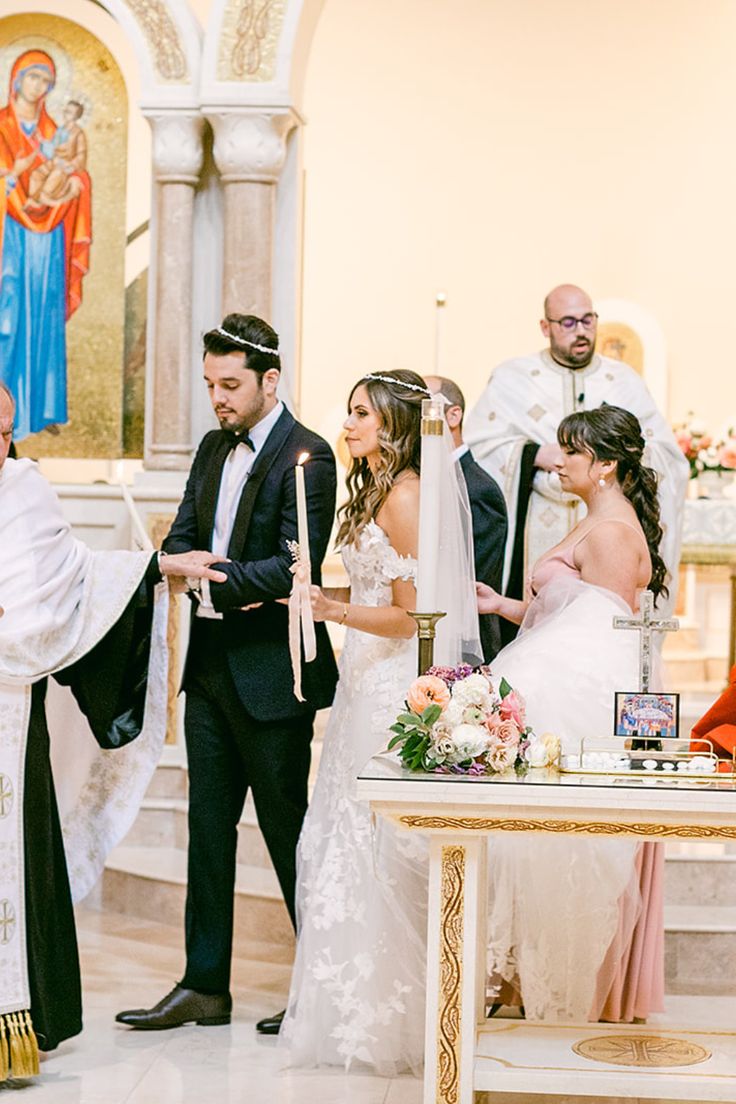 the bride and groom are getting married in front of the priest at their wedding ceremony