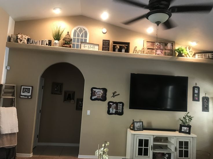 a living room filled with furniture and a flat screen tv mounted on a wall above a fireplace