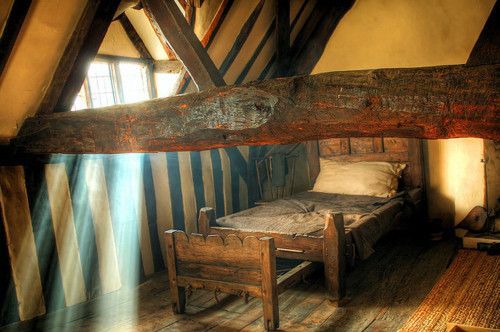 an old bed in a room with wooden beams