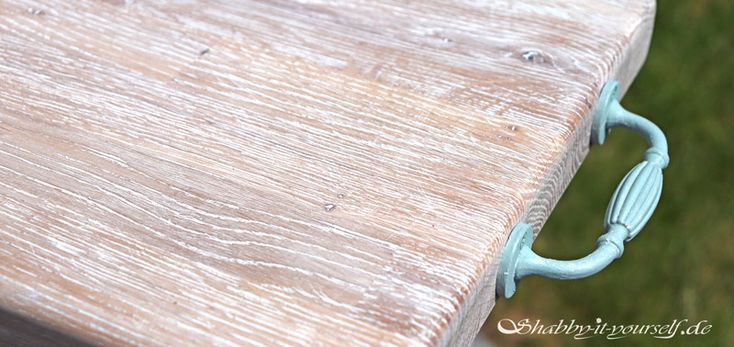 a close up of a wooden bench with metal handles