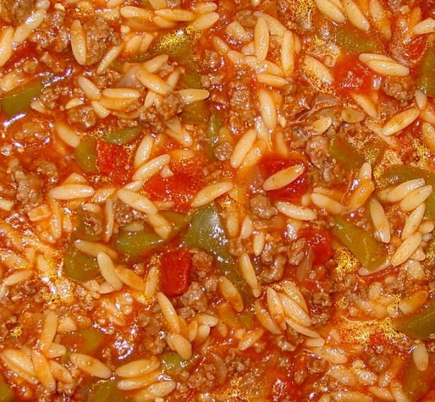 a close up view of some food in a pan with sauce and peppers on it