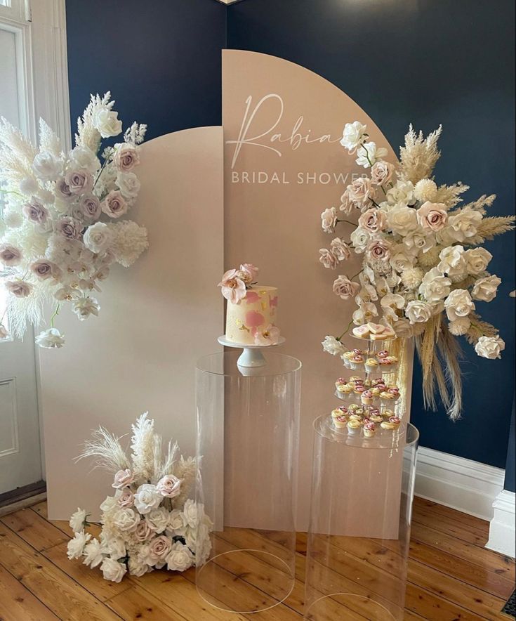 two tall vases with flowers are on the floor in front of a sign that says bridal show