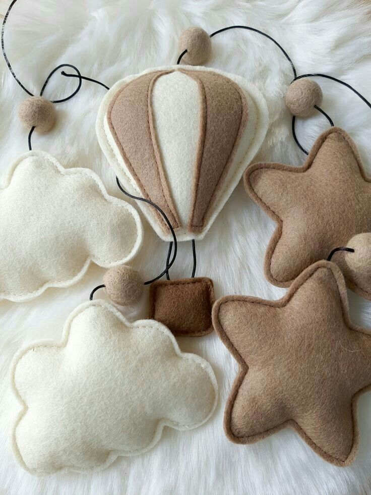 three felt hot air balloons sitting on top of a white rug