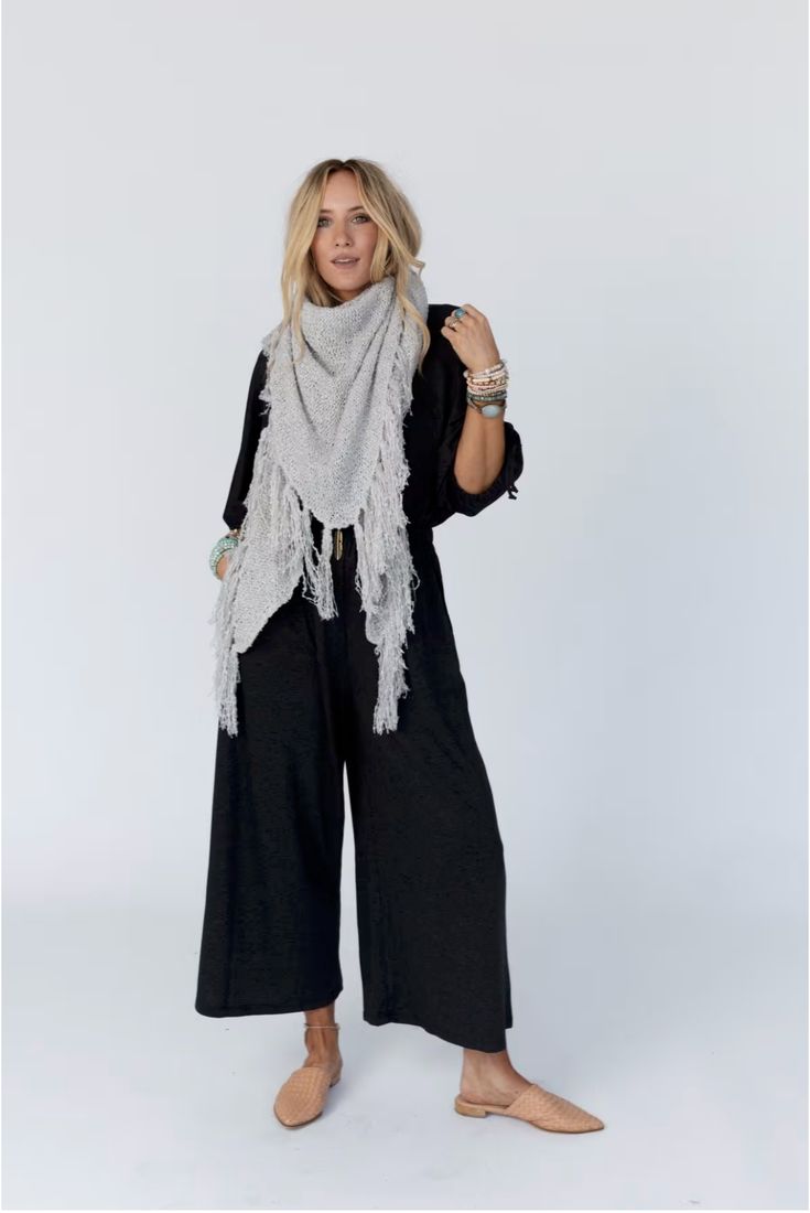 Drape yourself in the Moon Shadows Ruana Wrap and feel stylishly boho from day to night! This cozy-knit wrap features a loose and flowy silhouette, a beautiful triangular shape, and adorable tassel trim for a unique and versatile look. Infuse your wardrobe with some boho flair! Details: One size: 33 1/2"W x 86"L 100% Acrylic Hand wash cold, Lay flat to dry Import Bohemian Knit Shawl, Black Bohemian Scarf For Fall, Bohemian Fall Scarves With Tassels, Casual One Size Fringe Shawl, Casual One-size Shawl With Fringe, Casual Beach Shawl For Fall, Casual Fall Beach Shawl, Casual One Size Shawl For Festivals, Casual Poncho With Tassels For Festivals