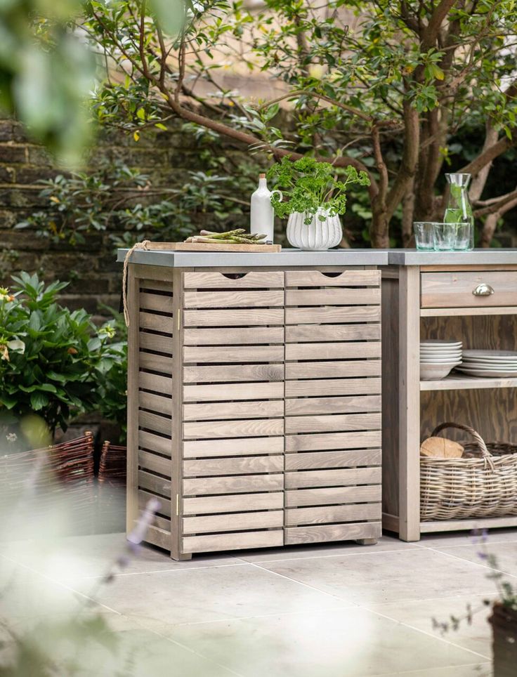 a wooden cabinet sitting next to a tree