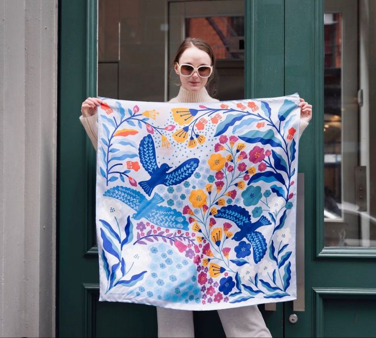 A woman holding up a silk scarf outside. Print Scarf Design, Silk Scarf Design, New York Design, Luxury Scarf, Hand Painted Scarves, Head Scarf Styles, Painted Scarf, Art Scarves, Silk Scarf Painting