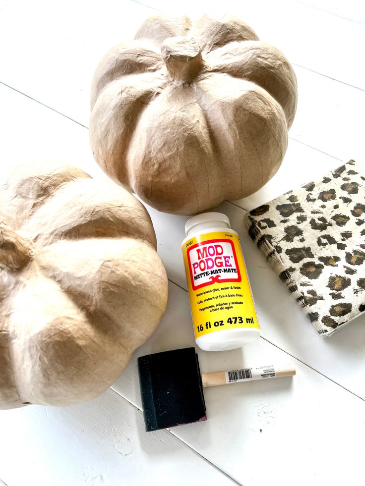 pumpkins, glue and other craft supplies on a white table with a leopard print napkin