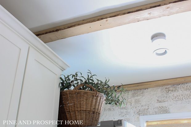 a basket is hanging from the ceiling in a kitchen