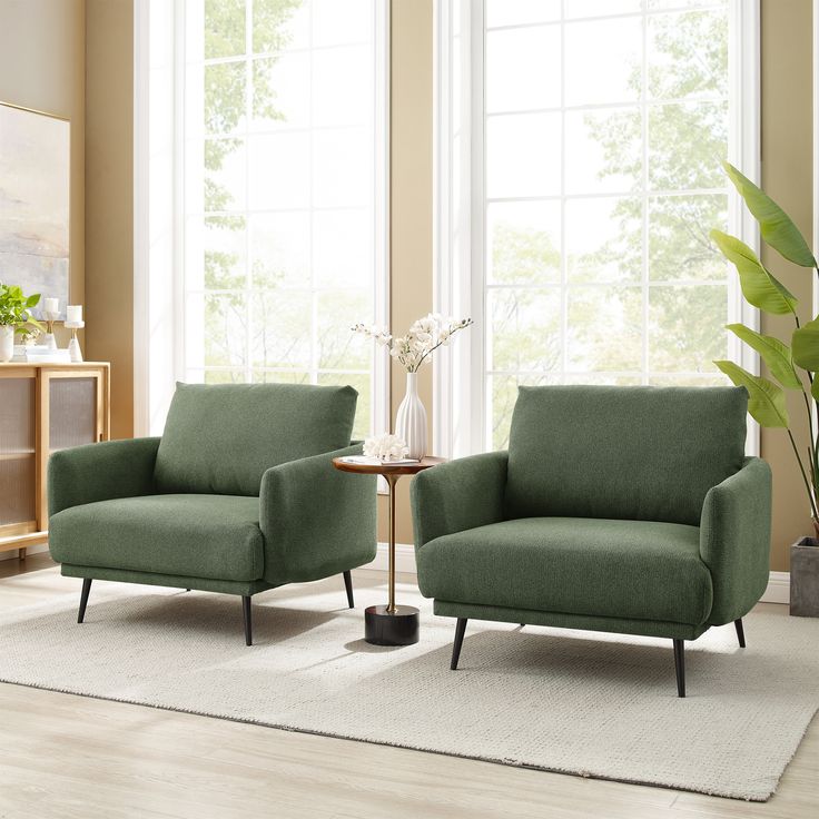 a living room with two green chairs and a table