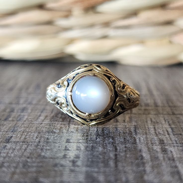 Antique 1846 Victorian Moonstone Cabochon Ring with Black Enamel in 18k Yellow Gold | Mourning Ring | Memorial Jewelry Phenomenal estate moonstone ring for the discerning collector.  This late Georgian/ Early Victorian era piece is fashioned from substantial 18k yellow gold, and features a cabochon cut moonstone with black enamel detailing.  The moonstone has a creamy color with grays. This is a memorial ring and the inscription reads: Robert Burra born 25 april 1767, died 28 Jan 1846. DETAILS/MEASUREMENTS: Moonstone - about 8 mm  Face - 13.5 mm wide in the center Shank - 3.10 mm in back Height- 8.15 mm Weight -6.36 grams Hallmarks/Stamps - Faded/partial London mark and partial mark remaining of Victoria duty for 18k gold.  Currently a size 9- Can be resized by your jeweler or by ours for Luxury Vintage Moonstone Oval Cabochon Ring, Luxury Antique Cabochon Pearl Ring, Luxury Engraved Oval Cabochon Jewelry, Engraved Moonstone Round Jewelry, Round Engraved Moonstone Jewelry, Engraved Round Moonstone Jewelry, Heirloom Gold Opal Cabochon Ring, Heirloom Gold Opal Ring With Cabochon, Heirloom Gold Moonstone Jewelry