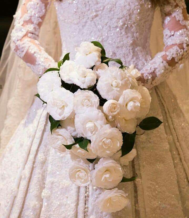 a bridal holding a bouquet of white flowers