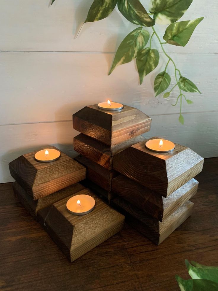 a stack of wooden blocks with lit candles