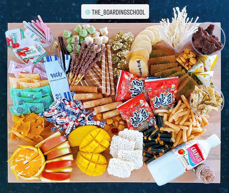 an assortment of snacks and condiments laid out on a cutting board with the words'the diamond school'above it