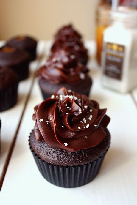 cupcakes with chocolate frosting and sprinkles are lined up on a table