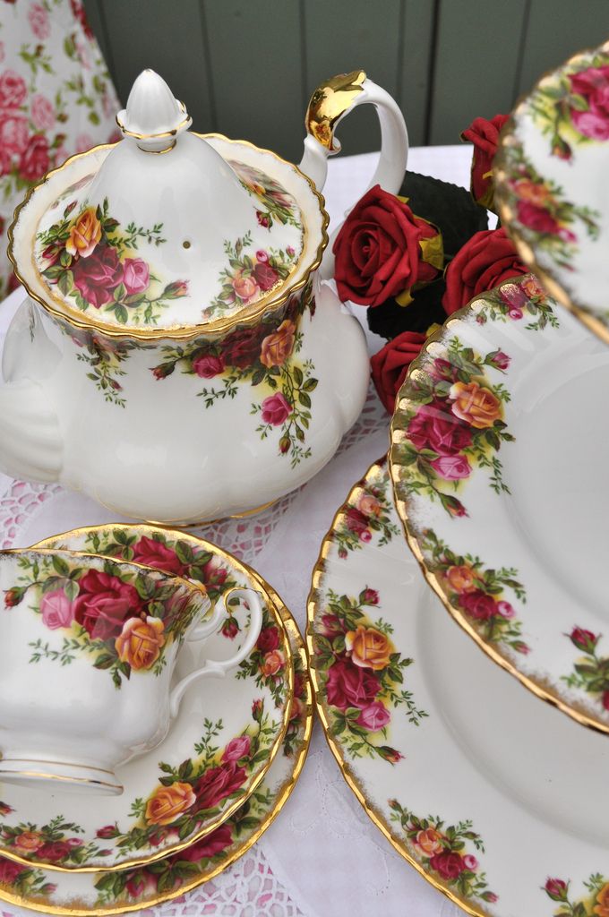 a table topped with plates and cups covered in flowers