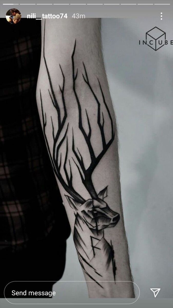 a man's arm with a deer and tree tattoo on the left side of his arm