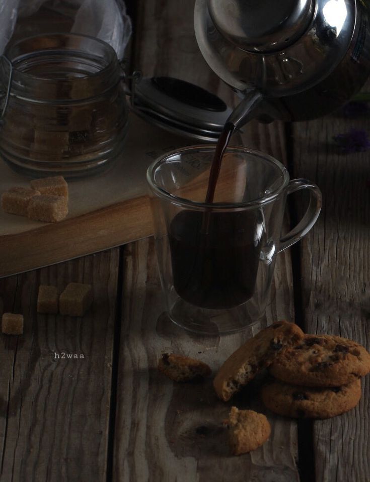 cookies and coffee being poured into a glass mug