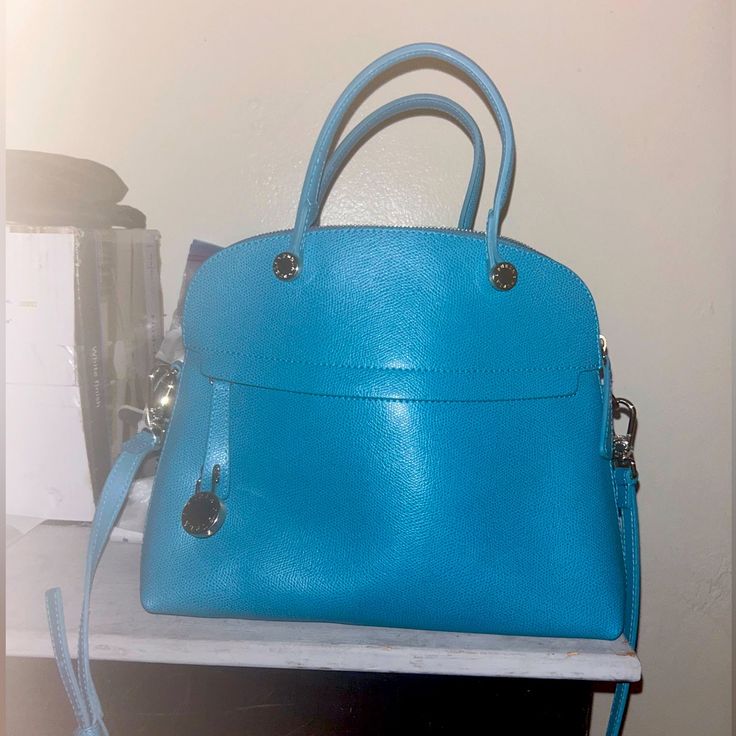 Never Used Furla Bag Luxury Blue Bag For Everyday Use, Luxury Blue Crossbody Satchel, Luxury Blue Shoulder Bag For Daily Use, Luxury Blue Top Handle Bag, Luxury Blue Shoulder Bag, Elegant Turquoise Shoulder Bag, Turquoise Crossbody Bag With Detachable Strap, Elegant Turquoise Bag With Removable Pouch, Elegant Blue Satchel For Everyday Use